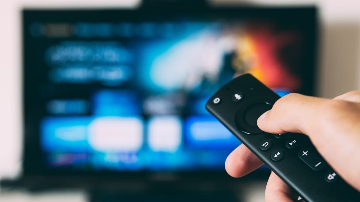 Amazon Fire TV remote pointed at a TV showing an IPTV app