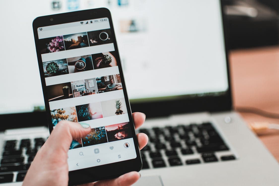 Setting up an IPTV app on an iPhone next to a laptop